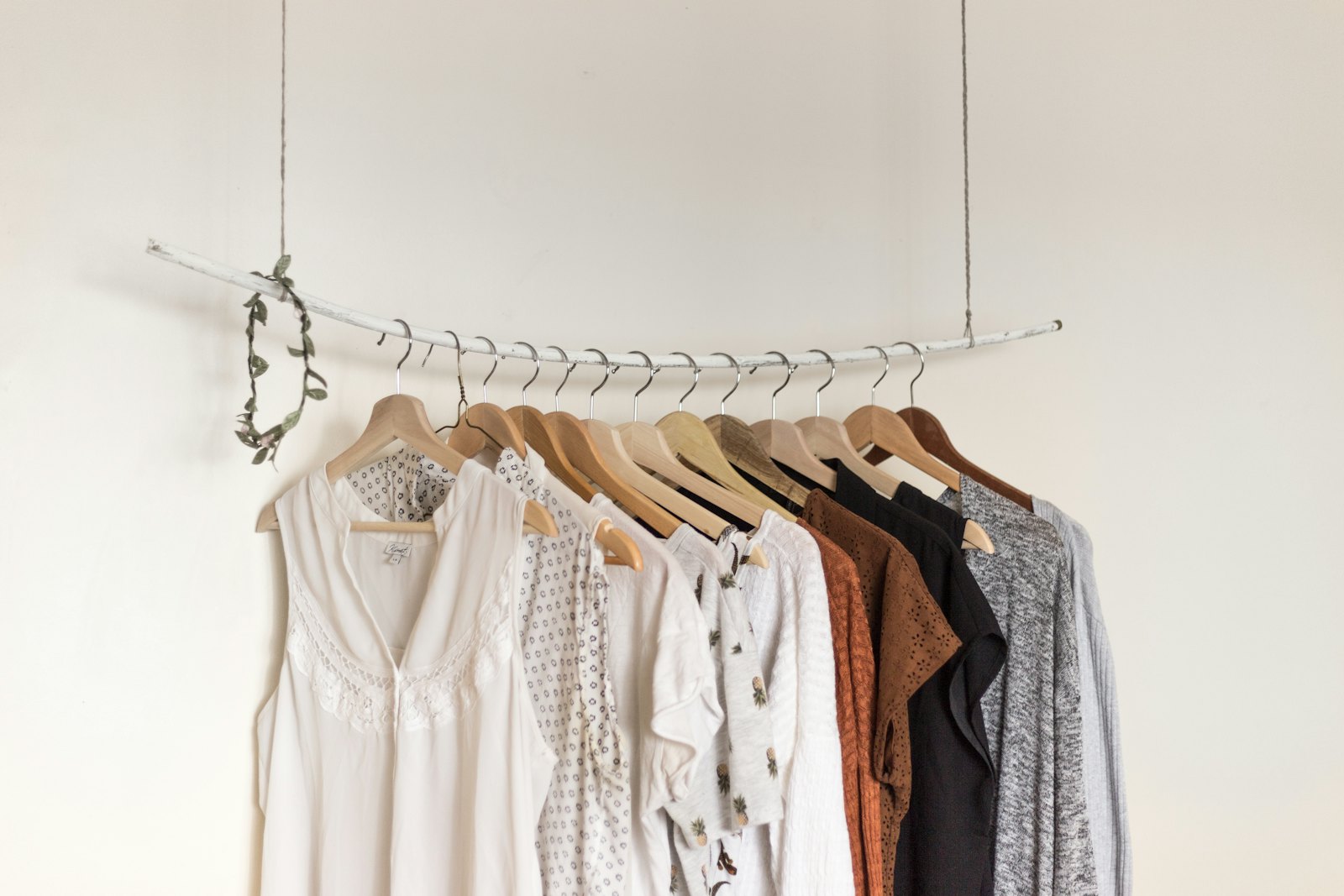 Minimalist clothes rail with linen garments against a white wall, capturing the pared-back A.P.C. homeware mood