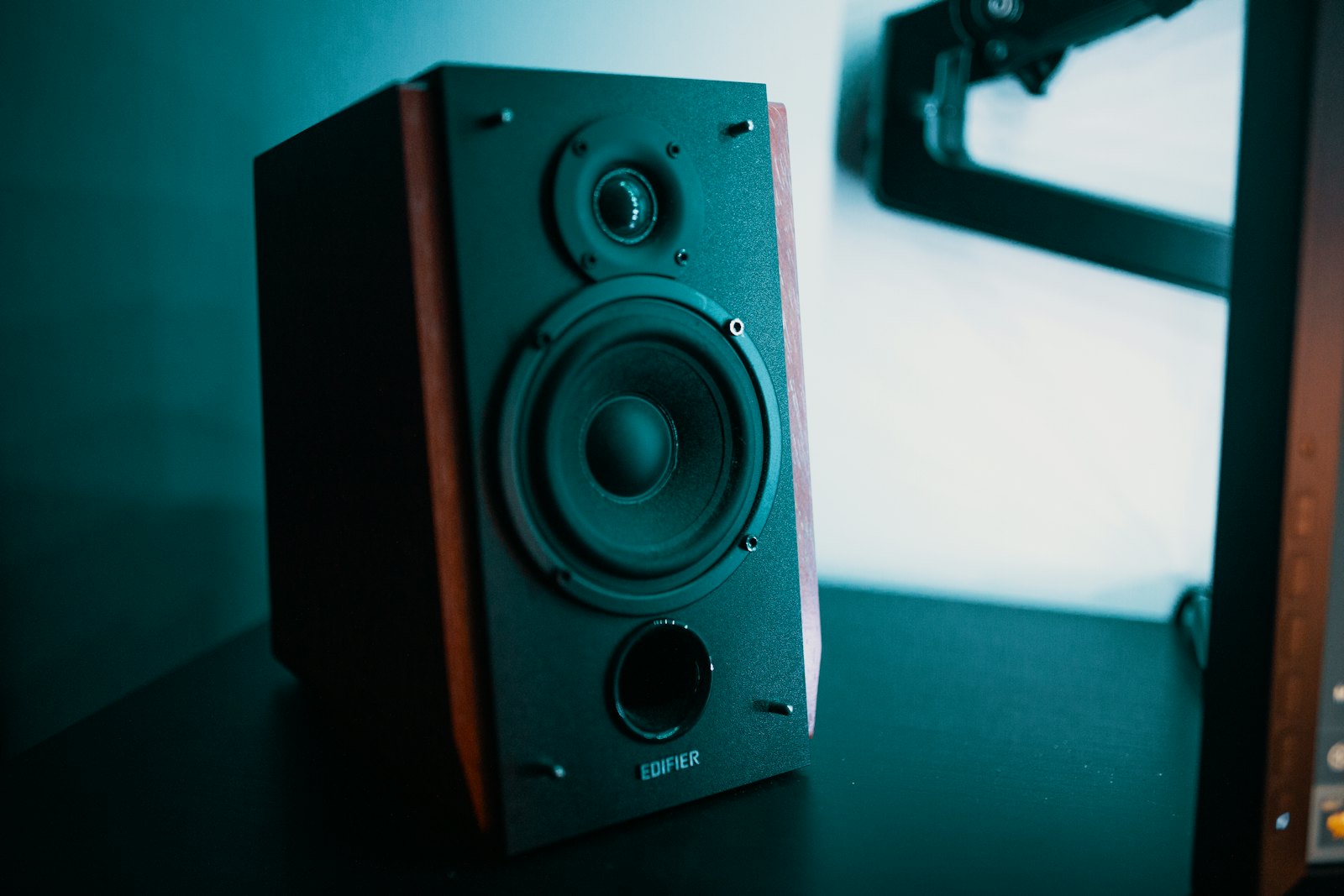Wooden-cased speaker on a teal background, styled to show off colourful Kakkoii Pantone speakers